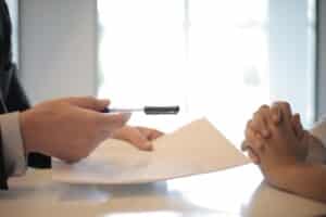 Lawyer handing a document and pen to client