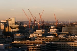 Construction cranes over city skyline at dusk